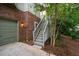 View of the home's garage, brick facade, and exterior stairs to the main level at 244 Sweet Bay Pl, Carrboro, NC 27510