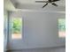 Bedroom features two windows, a ceiling fan, and neutral-toned carpet at 28 Carteret Ct, Clayton, NC 27527