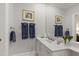 Well-lit bathroom with a white vanity, a large mirror, and fresh, colorful flower decor at 2813 Market Bridge Ln # 104, Raleigh, NC 27608