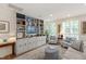 Bright living room features custom built-ins, plush seating, and light-filled windows with plantation shutters at 2813 Market Bridge Ln # 104, Raleigh, NC 27608