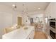 Open kitchen features a white quartz countertop island with bar stools, stainless appliances, and wood flooring at 2940 C Chapel Hill Road, Durham, NC 27707