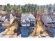 An elevated view of a home showcasing a three-car garage within a tree-lined neighborhood at 309 Malvern Hill Ln, Morrisville, NC 27560