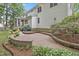 Spacious backyard patio with brick pavers, garden beds, and mature trees at 314 Chanticlair Dr, Apex, NC 27502