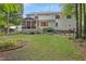 Spacious backyard with a screened porch, lush lawn, mature trees, and garden at 314 Chanticlair Dr, Apex, NC 27502