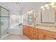 Bright bathroom featuring double vanity, granite countertops, a soaking tub, and a glass shower at 314 Chanticlair Dr, Apex, NC 27502