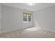 Simple and bright bedroom with neutral walls, carpet, a window, and electrical outlets at 314 Chanticlair Dr, Apex, NC 27502