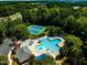 Aerial view of the community pool, tennis courts, and surrounding trees at 314 Chanticlair Dr, Apex, NC 27502