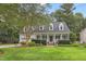 Charming two-story home featuring a covered front porch, beautiful landscaping, and a well-manicured lawn at 314 Chanticlair Dr, Apex, NC 27502