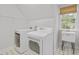 Bright laundry room with utility sink, washer, dryer, and overhead storage at 314 Chanticlair Dr, Apex, NC 27502