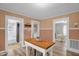Bright kitchen featuring a central island, view into dining room, and adjacent bathroom at 3315 Mebane Oaks Rd, Mebane, NC 27302