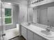 Bathroom featuring double sinks and vanity with a view of the exterior at 3509 Neptune Dr, Raleigh, NC 27604
