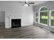 Inviting living room featuring hardwood floors, a cozy fireplace, and large windows overlooking the yard at 3509 Neptune Dr, Raleigh, NC 27604