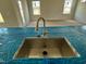 Close-up of a kitchen island with a stainless steel sink and a view of the open-concept living space at 40 Commons Cir, Clayton, NC 27520