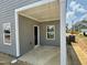 Covered patio with gray siding, offering an ideal outdoor living space for relaxing or entertaining at 40 Commons Cir, Clayton, NC 27520