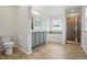 This bathroom features tile floors, a tiled shower, a soaking tub, and a gray vanity at 409 Kilcornac Ct, Fuquay Varina, NC 27526