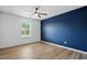 This bedroom features hardwood floors, a blue accent wall, and a ceiling fan at 409 Kilcornac Ct, Fuquay Varina, NC 27526