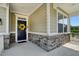 Covered front porch featuring stone accents, white trim, and a welcoming black door with decorative wreath at 409 Kilcornac Ct, Fuquay Varina, NC 27526