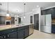 Open concept kitchen features stainless appliances, a breakfast bar, tile floor and dark cabinets at 409 Kilcornac Ct, Fuquay Varina, NC 27526