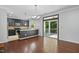 A bright eat-in kitchen features stainless appliances, dark cabinets, hardwood floors and glass doors to an outdoor deck at 409 Kilcornac Ct, Fuquay Varina, NC 27526