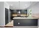 Modern kitchen with stainless steel appliances, dark cabinets, breakfast bar, and tile backsplash at 409 Kilcornac Ct, Fuquay Varina, NC 27526