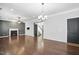 Spacious living room with hardwood floors, fireplace, dark accent wall, and a modern light fixture at 409 Kilcornac Ct, Fuquay Varina, NC 27526