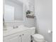 This half bathroom features a white sink, toilet, and a decorative shelf with art and plant at 4401 Lyman Ave, Raleigh, NC 27616