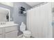 This full bathroom features gray walls, shelving over the toilet, and a shower with curtain at 4401 Lyman Ave, Raleigh, NC 27616