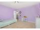 This bedroom features lavender walls, a white desk, and a bed with neutral linens at 4401 Lyman Ave, Raleigh, NC 27616