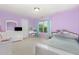 A bedroom with lavender walls, featuring a desk, dresser, and bed at 4401 Lyman Ave, Raleigh, NC 27616
