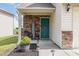 Cozy front porch with stone accents and a welcoming teal door at 4401 Lyman Ave, Raleigh, NC 27616