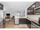 Modern kitchen with stainless steel appliances, granite countertops, and dark wood cabinetry, flowing into the living area at 4401 Lyman Ave, Raleigh, NC 27616