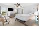A spacious main bedroom with ceiling fan, a large bed, two windows and a work space at 4401 Lyman Ave, Raleigh, NC 27616