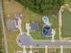 Aerial view of a neighborhood featuring manicured lawns, a pool, and tree-lined streets at 470 E Wellesley Dr, Clayton, NC 27520
