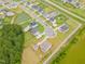 Aerial view of a residential neighborhood featuring well-maintained homes, lush green lawns, and a tranquil pond at 470 E Wellesley Dr, Clayton, NC 27520