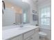 Bright bathroom with a white vanity, large mirror, and a window offering a pleasant view at 470 E Wellesley Dr, Clayton, NC 27520