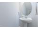 Powder room features pedestal sink, chrome faucet, and round mirror at 470 E Wellesley Dr, Clayton, NC 27520