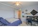 Blue-walled bedroom featuring a ceiling fan, a work station, and a door leading to the hallway at 470 E Wellesley Dr, Clayton, NC 27520