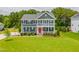 Charming gray two-story home featuring a inviting porch, manicured lawn, and a vibrant red front door at 470 E Wellesley Dr, Clayton, NC 27520