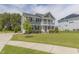 Well-manicured lawn and lovely gray home featuring a double porch and convenient driveway basketball hoop at 470 E Wellesley Dr, Clayton, NC 27520