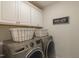 This laundry room features white cabinets and a new washer and dryer at 470 E Wellesley Dr, Clayton, NC 27520