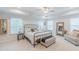 Spacious main bedroom featuring a tray ceiling, a ceiling fan, multiple windows, and a sitting area at 470 E Wellesley Dr, Clayton, NC 27520