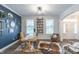 Home office with a dark blue accent wall, custom shelving, a modern desk, and comfortable seating at 470 E Wellesley Dr, Clayton, NC 27520