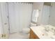 Bright bathroom with white tile, white shower curtain, and single sink vanity at 4810 Glenmist Ct, Raleigh, NC 27612
