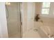 Bathroom highlighting a walk-in shower, soaking tub, and window with plantation shutters at 4810 Glenmist Ct, Raleigh, NC 27612