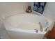 Large white corner bathtub features tile surround and chrome fixtures at 4810 Glenmist Ct, Raleigh, NC 27612