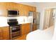 Modern kitchen with stainless steel appliances, wood cabinets, and hardwood floors at 4810 Glenmist Ct, Raleigh, NC 27612