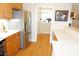 Open kitchen area with stainless steel refrigerator and hardwood floors at 4810 Glenmist Ct, Raleigh, NC 27612