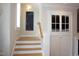 Stairway with wood steps and white banister, window with plantation shutters and built in storage cabinet at 4810 Glenmist Ct, Raleigh, NC 27612