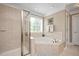 Bright bathroom featuring a large soaking tub and separate glass shower at 517 Wheddon Cross Way, Wake Forest, NC 27587