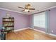 Cozy bedroom with hardwood floors, a bookshelf, and a ceiling fan at 517 Wheddon Cross Way, Wake Forest, NC 27587